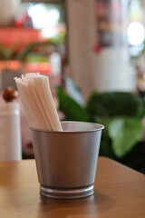 Calm close up of chopstick container on wood table inside restaurant. background has soft blur, creating peaceful atmosphere for quiet meal and dining experience