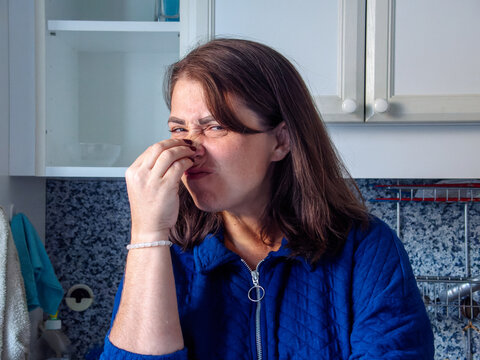 Expression of disgust in a cozy kitchen setting during a sunny afternoon
