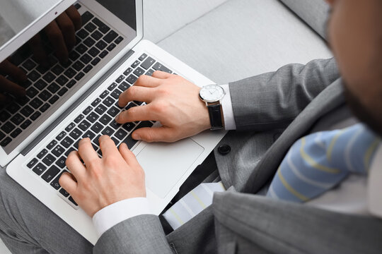 Businessman with wristwatch using laptop in office, closeup