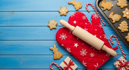 Christmas baking supplies and festive cookies on blue wood