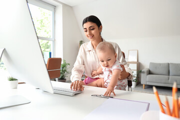 Young business mother with computer and cute little baby working at home