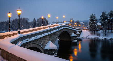 Snowcovered stone bridge illuminated by streetlights over a calm river at dusk creates a serene winter scene with reflections in the water