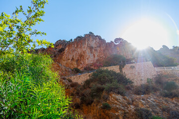 Naklejka premium The bright rays of the sun shining through the mountain ridge create an interesting overexposed effect
