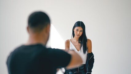 Photographer capturing stunning images of a beautiful young female model posing elegantly in a professional studio setting