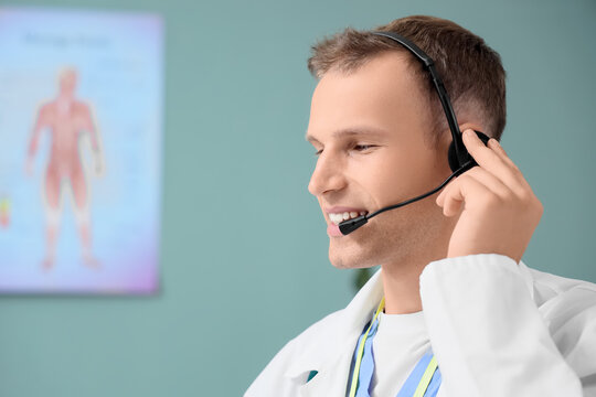 Young male doctor with headset giving consultation online in clinic, closeup