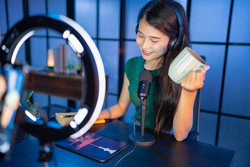 Content creator Young asian woman influencer creating content in home studio entertainment and communication blogger video record with smartphone for online vlog