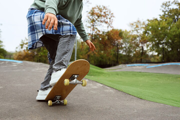 Legs of young man with skateboard in park, closeup