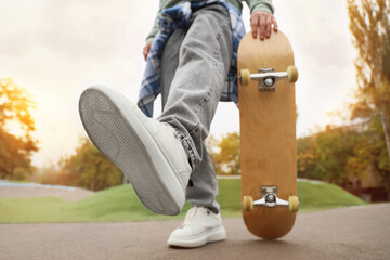 Legs of young man with skateboard in park, closeup