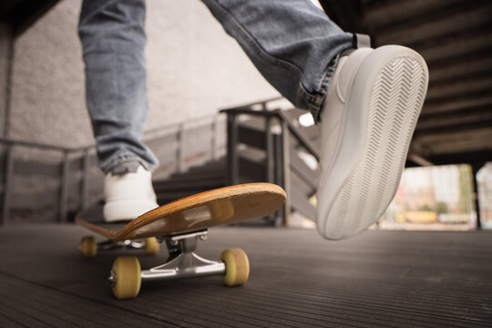 Legs of young man with skateboard outdoors, closeup