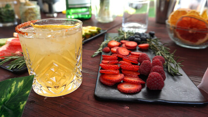 Refreshing Tropical Pineapple Cocktail with Berries Served on Wooden Table / Cóctel Tropical de...