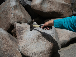Woman Tapping a Hammer on a Ringing Rock in Montana
