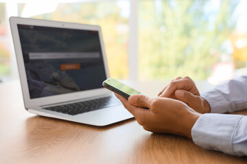 Naklejka premium Businesswoman's hands using mobile phone to search for tickets online in office, closeup