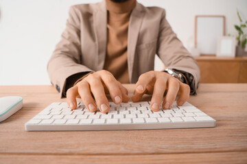 Young businessman using computer to search online in office, closeup
