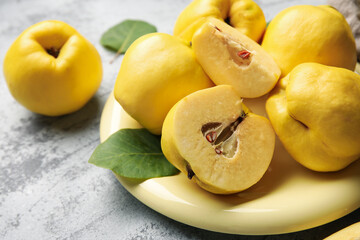 Plate with sweet ripe quinces on grey background, closeup