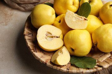 Wicker plate with sweet ripe quinces on white background, closeup