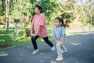 Obraz premium An elderly woman and a young girl practice lunges outdoors in a lush green park, promoting fitness, strength, and wellness across generations, enabling healthy habits