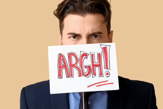 Angry businessman with paper sign on beige background, closeup