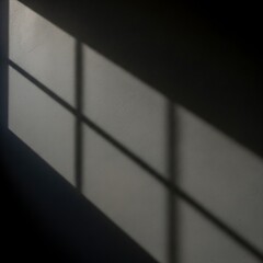 Shadows cast by a window frame on a white wall, creating geometric patterns.