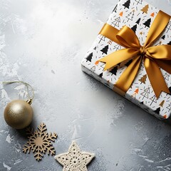 Festive gift box with gold ribbon and ornaments on a textured surface.