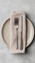 Elegant Place Setting with Silverware on Neutral Plate and Textured Napkin Against Gray Textured Background