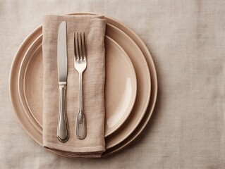 Elegant Place Setting with Stacked Plates and Silverware on Neutral Woven Tablecloth