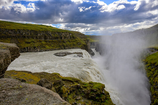 Gulfoss waterfall Water curtain cascading over green mossy cliff