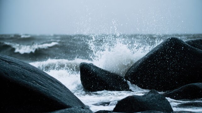 Ocean waves crashing against dark rocks with splashing water droplets in dramatic seascape. travel magazines, destination branding, designed for outdoor magazines and nature guides.