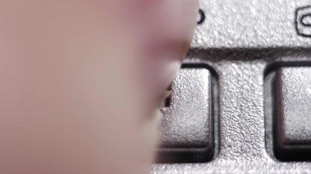 Close-up of a silver stop button with a square icon being pressed on a vintage media device