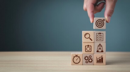 Human hand places final wooden block marked with an arrow striking a target atop a growing stack of concept icons