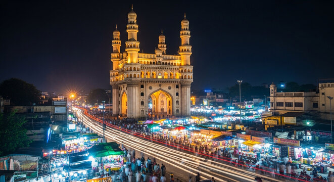Charminar monument illuminated at night with bustling crowds and street lights in hyderabad, india