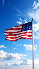 Naklejka premium The American flag flutters in the wind against a bright blue sky
