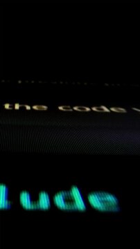 Closeup macro shot movement of coding script moving across LED screen with real-time AI-generated typing, showcasing advanced AI learning in optimization, debug and coding for software development.
