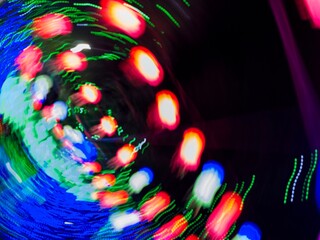 Neon light motion blur abstract background. Abstract blue, orange and green lights trail on the dark background