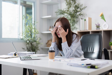 Obraz premium Travel Planning: Stressed woman rubbing her eyes at home office