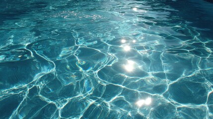 Bright sunlight reflects off the surface of a clear swimming pool creating sparkling patterns in the water. The scene conveys calm and relaxation on a warm day.