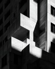 Fototapeta premium Stark Concrete Architecture - Geometric Shadows and Light on Modern Building Facade.