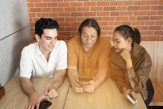 Friendly coworkers meeting casual teamwork mobile phone coffee shop modern office brick wall natural light collaborative discussion diverse team relaxed mood. Team sharing ideas while smiling