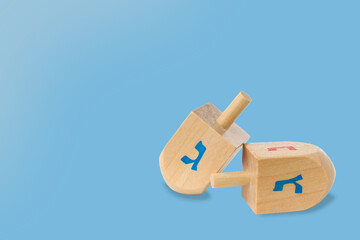 Fototapeta premium Wooden dreidels with blue and red symbols on a blue background