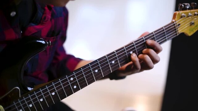 Close Up of Musician Playing Electric Guitar  in rehearsal studio  details on fingerboard
