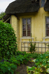 The Hameau de la Reine at Trianon, Marie Antoinette’s pastoral estate with charming rustic cottage buildings, landscaped flower gardens, showcasing  historic elegance and beauty of French countryside © faestock