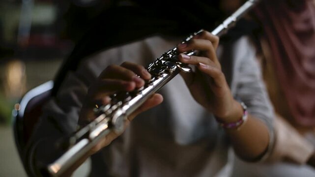 Close Up of Musician Playing Silver Flute in rehearsal studio