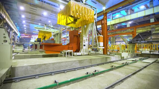 Industrial Factory Floor with Large Yellow Overhead Cranes and Manufacturing Equipment