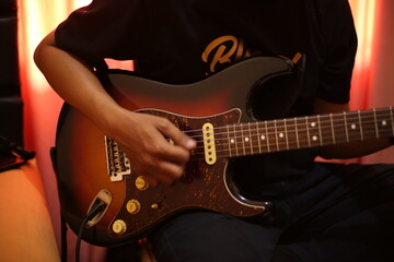 Fototapeta premium Close-Up of hand Musician Playing Electric Guitar in rehearsal studio