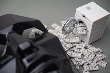 Washing machine is cleaning many US dollar bill banknotes with scammer mask. Money laundering from scam, criminal activity, corruption, etc. or law and enforcement concept.