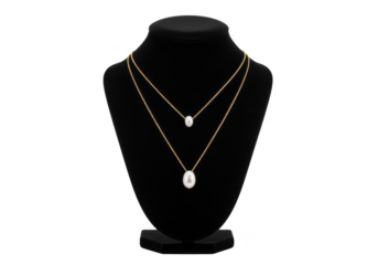 Layered gold chain necklaces with white pearls displayed on a black bust. isolated on transparent background