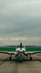 White Propeller Plane on Tarmac Under Cloudy Sky