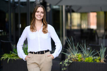 Ambitious female executive rejoices in professional success while standing outside retail store or street cafe. Successful small business owner, business concepts