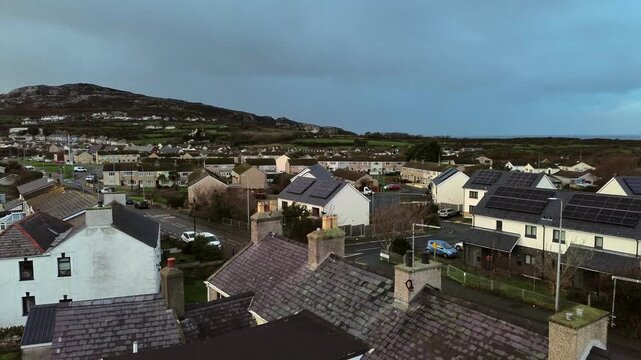 Rainy Holyhead homes aerial view rising over small island town neighbourhood mountain real estate