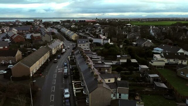Rainy Holyhead homes aerial view descent towards small island town neighbourhood real estate