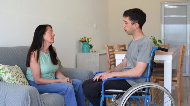 Man in a Wheelchair, Overwhelmed and Hurting, Confides in His Mother About the Anger He Feels Toward His Disability. medium shot